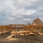 Wooden house framing under construction in Fort Worth, TX during a cloudy day.
