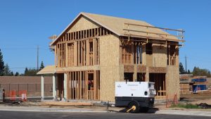 A new house under construction in Elk Grove, showing wooden framing and building materials.