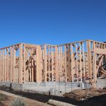 Wood framing of a house under construction in a sunny California subdivision.
