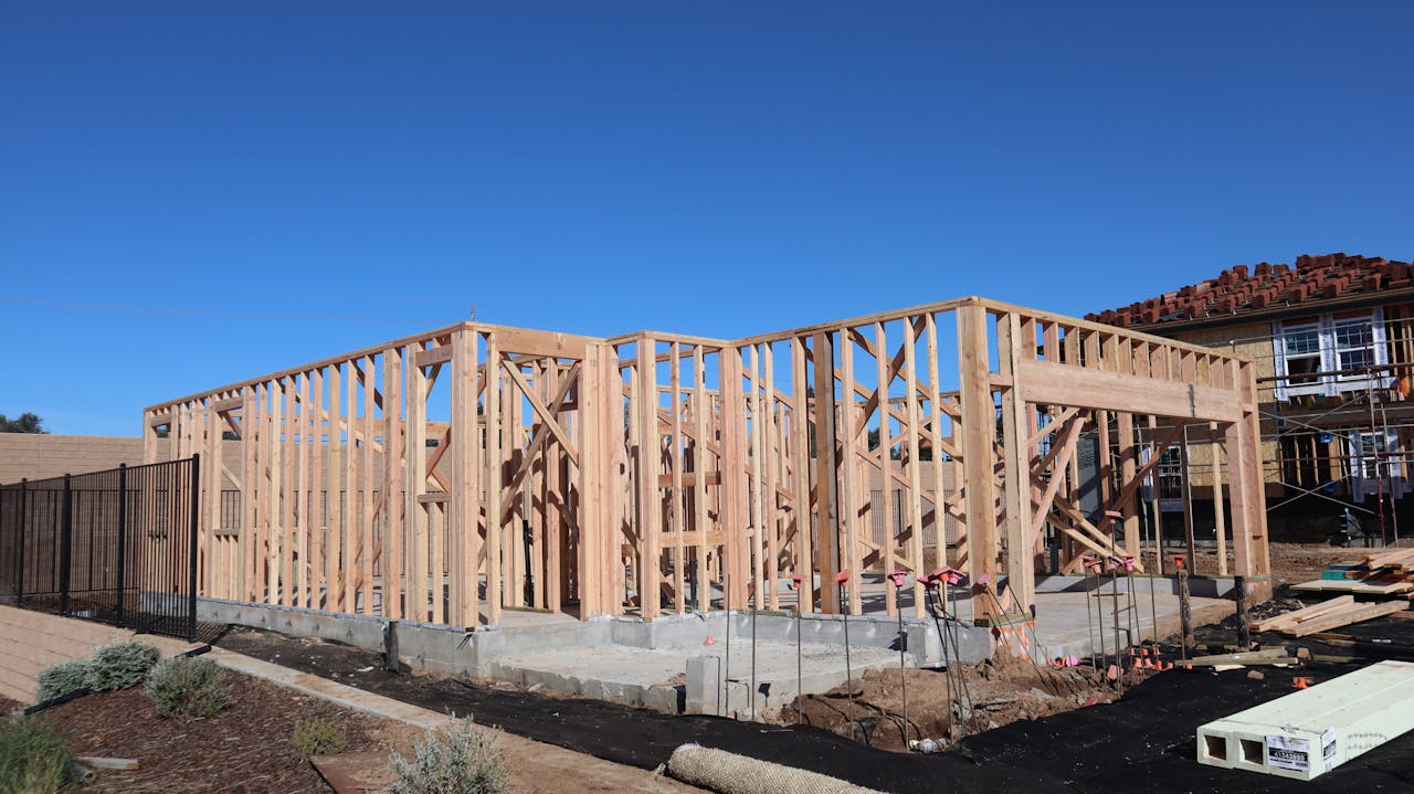 Wood framing of a house under construction in a sunny California subdivision.